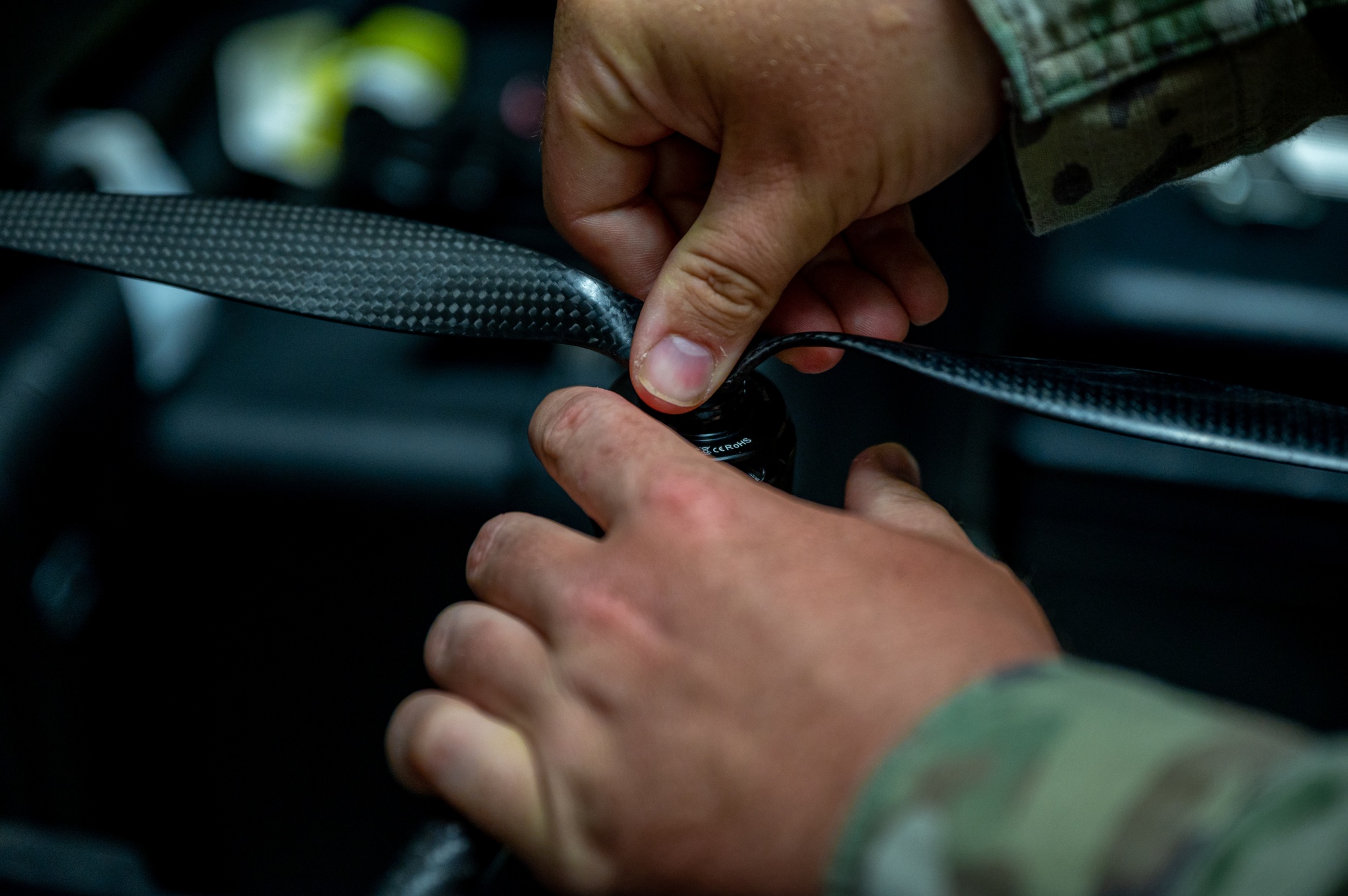 Close view of hands attaching a carbon-fiber propeller to a drone motor
