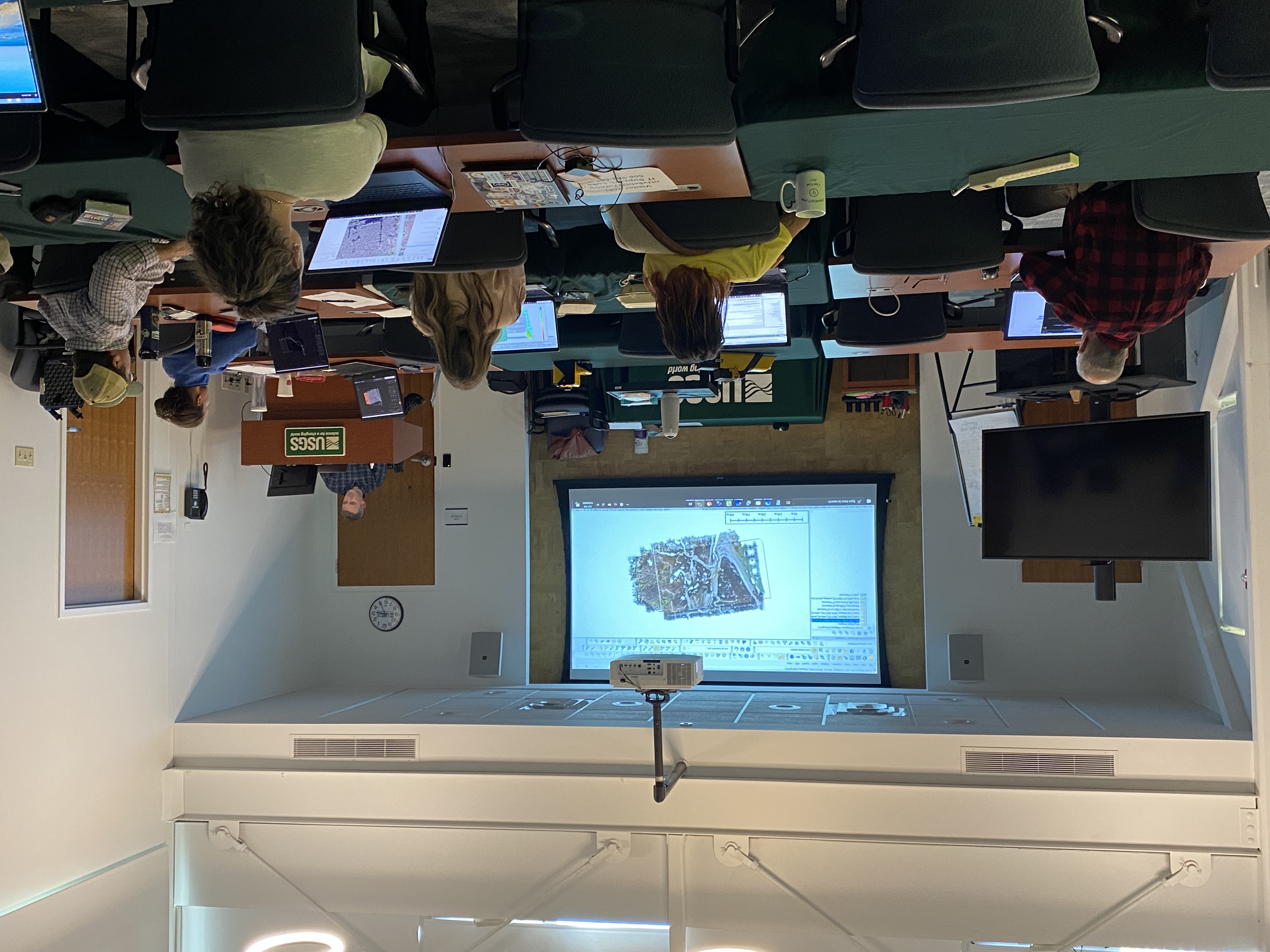 Participants use laptops while an instructor presents mapping software during a USGS lidar training workshop