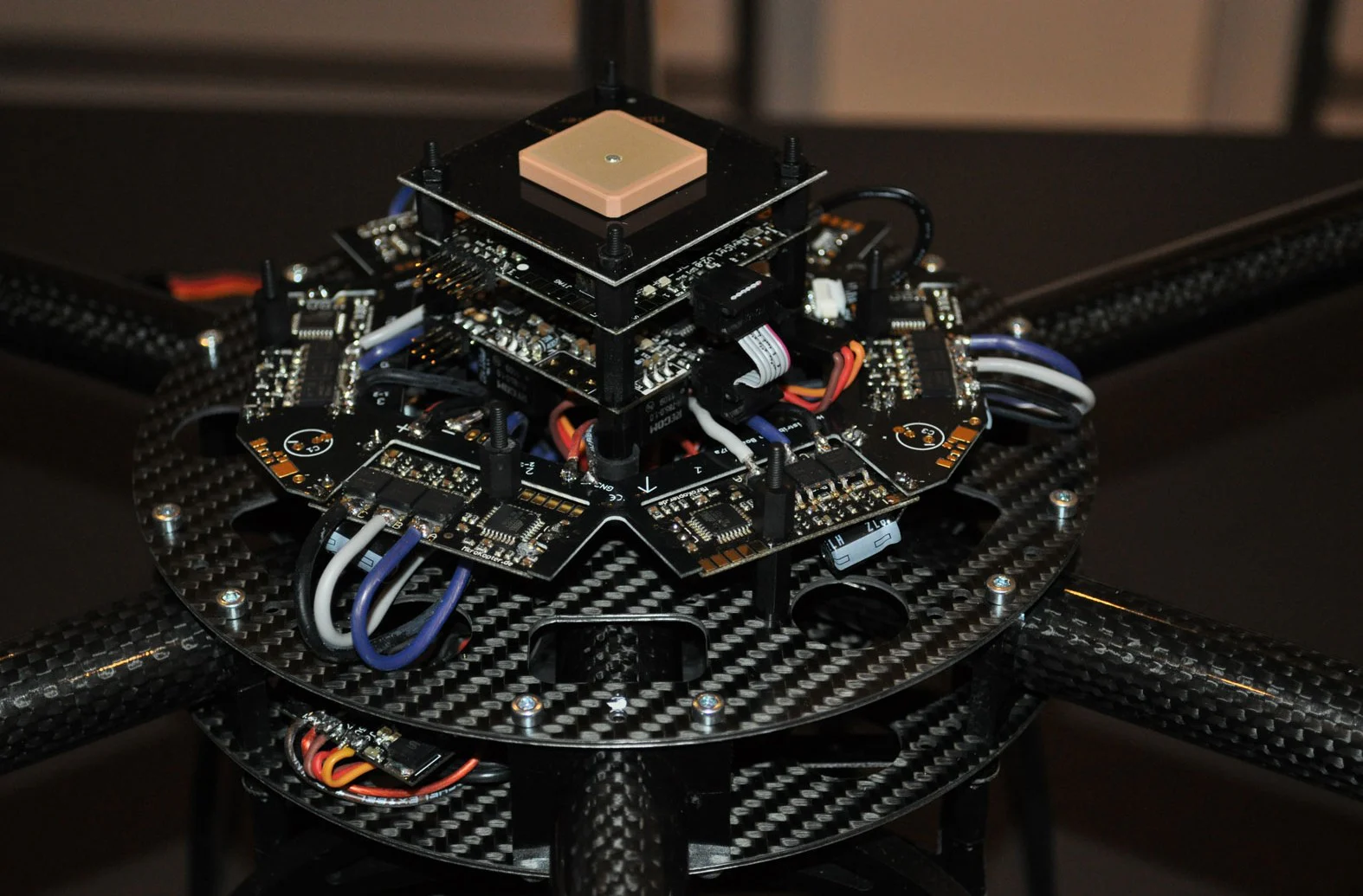 Exposed multicopter electronics showing a GPS antenna above navigation, flight-control, and motor-control boards.