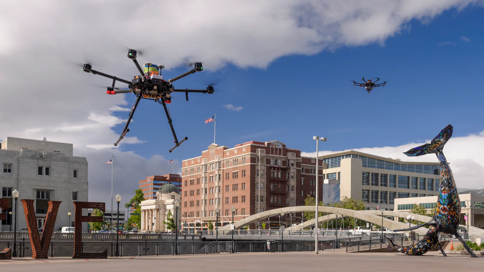 Two multirotor drones fly over downtown Reno during a NASA UAS Traffic Management test.